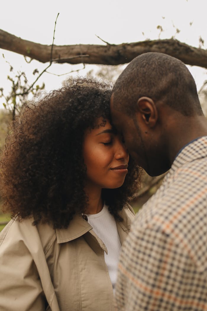 A couple sharing a tender forehead-to-forehead moment outdoors
