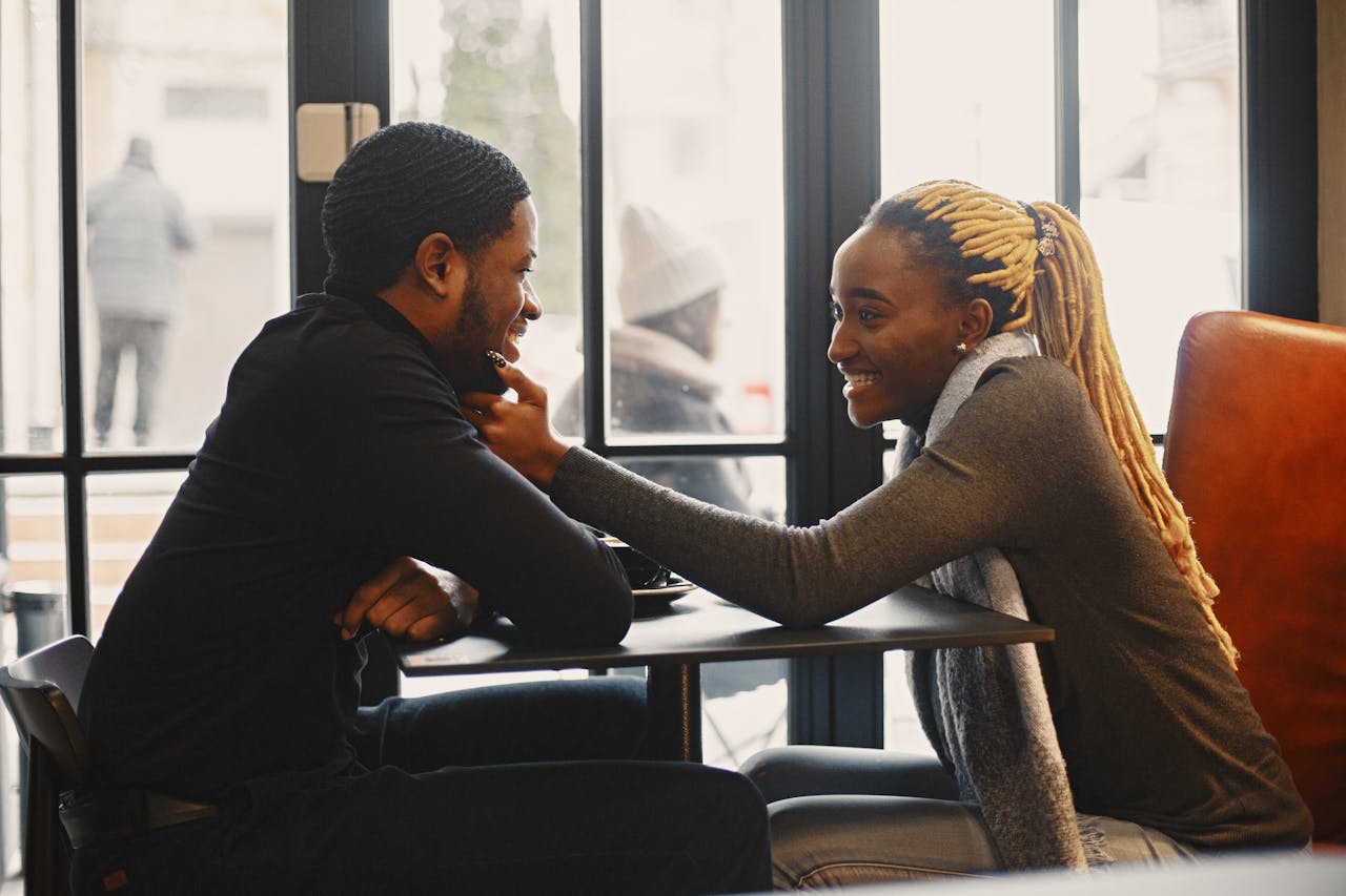 Happy couple enjoying a loving moment in a cozy cafe setting.