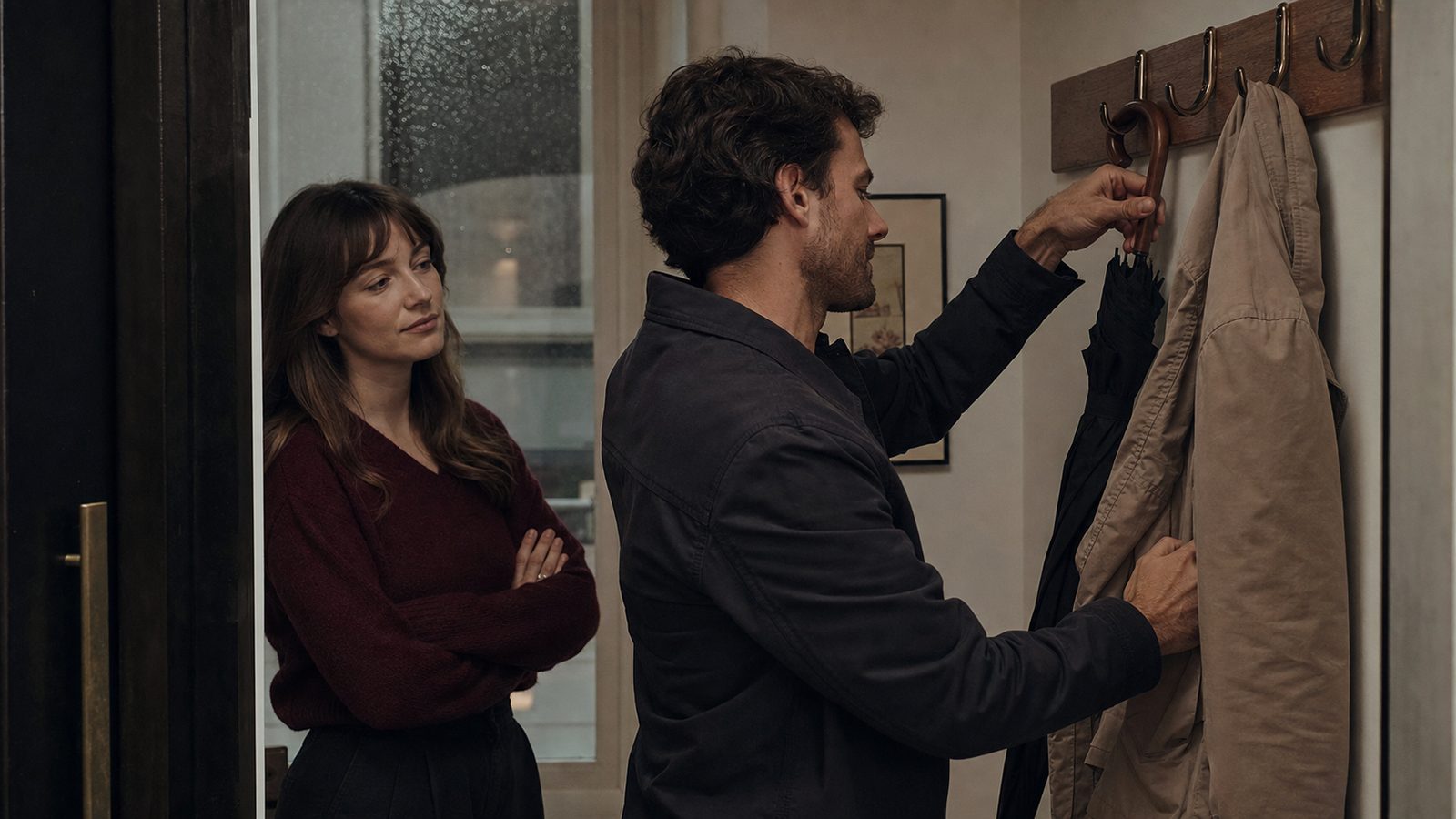 12 Ways Emotionally Unavailable Men Show Love Without Saying It A man quietly hangs up a coat and umbrella while a woman notices his subtle care