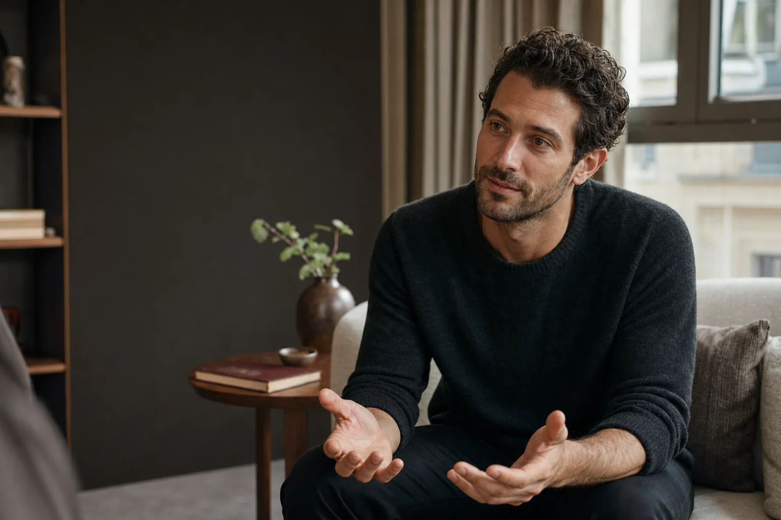 Emotionally present man listening with open hands in a calm living room